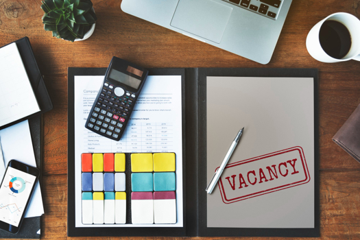 Creds: FreePik - a desk with a folder and a vacancy stamp inside